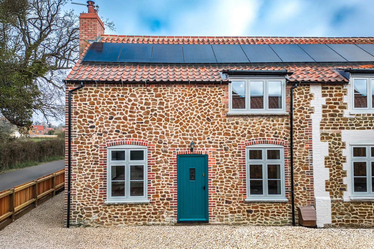 Project Gallery - 2 & 4 Common Road, Snettisham showing stunning renovated Norfolk flint cottage with teal door and solar panels