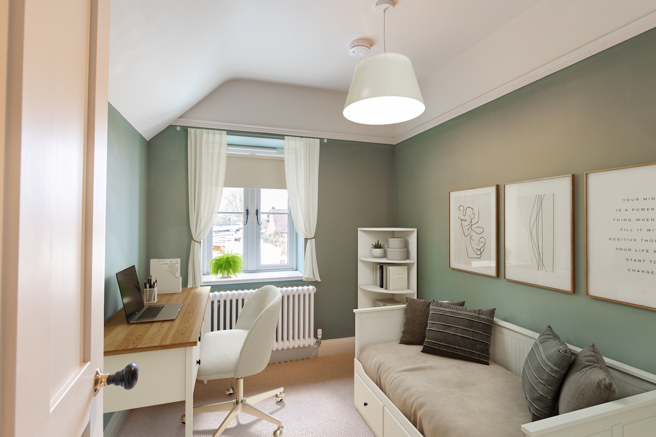 Home Office Interior - Sophisticated home office showing sage green accent walls, white built-in desk with wooden countertop, white swivel office chair, laptop workspace, white corner shelving unit with decorative items and plants, white column radiator, cream curtains at window, white pendant light fixture, framed line art prints in wooden frames with inspirational text, white daybed with grey cushions and patterned throw pillows, neutral carpet flooring, and white tongue-and-groove wainscoting demonstrating excellent space planning combining work and relaxation areas with cohesive sage green color scheme