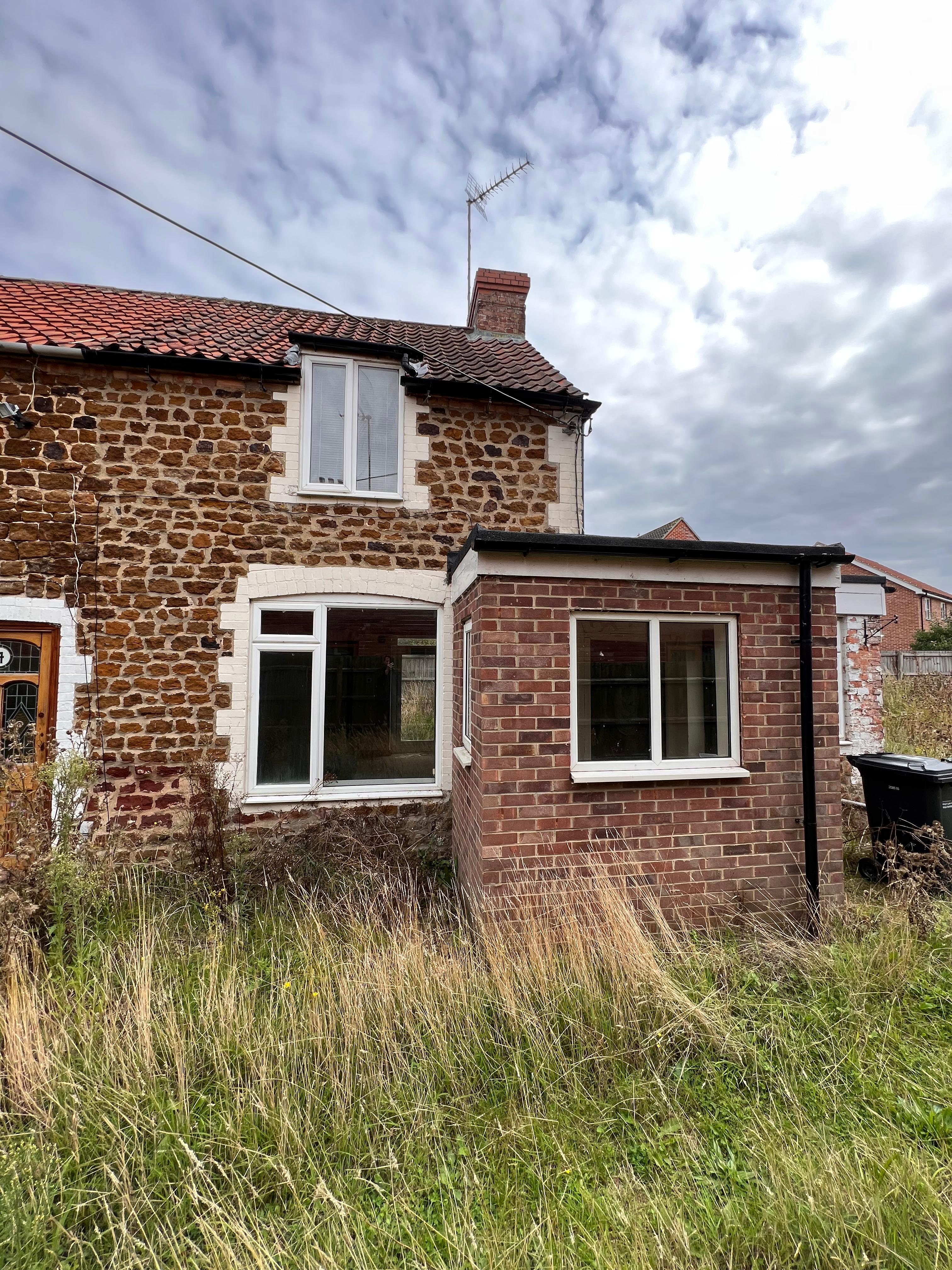Before renovation - 2 & 4 Common Road property with traditional Norfolk flint stone construction and overgrown surroundings